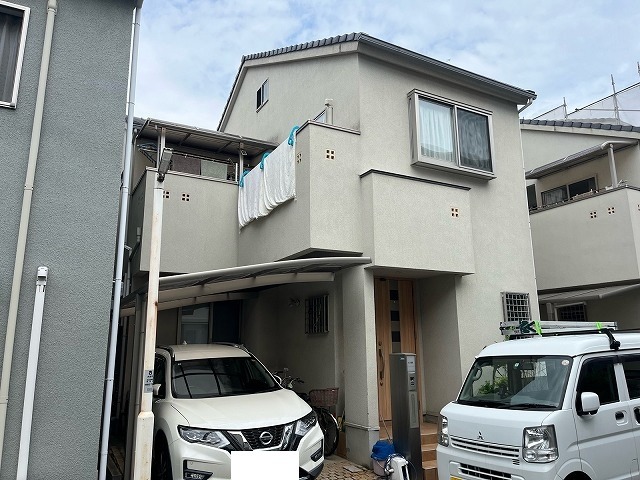 塗り替え前の大東市の戸建て住宅 リシン外壁全体がくすみ雨だれの筋が残る正面全景
