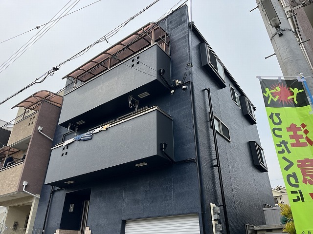 施工後の外壁全景。濃いネイビーに塗り替えた築20年サイディング外壁の3階建て住宅