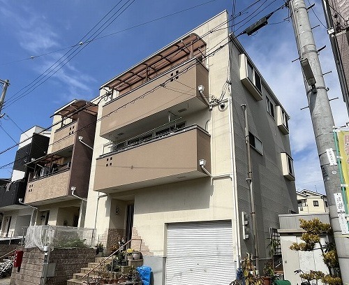 施工前の外壁全景。大東市谷川の築20年3階建て住宅、薄ベージュのサイディング外壁