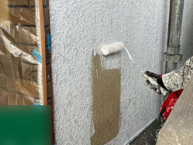 リシンの凹凸に押し込むようにフィラーをローラーで塗り込む下塗り作業