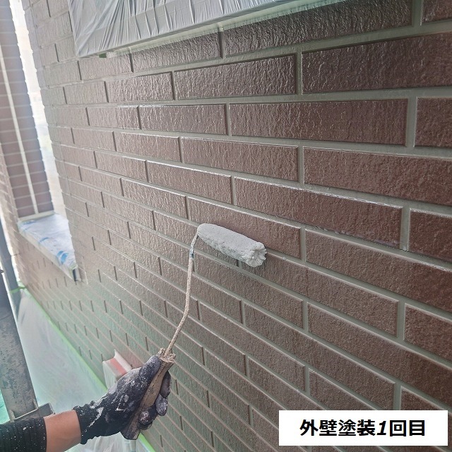 ブリック調の外壁にシーラーをローラーで塗る作業