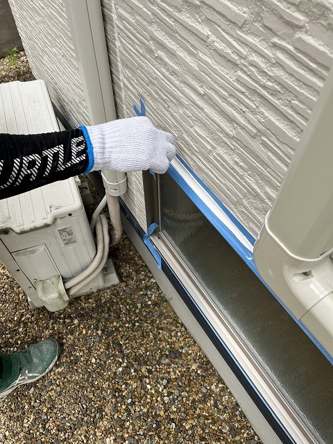 ヘラでシーリング材を押さえて空気を追い出している作業
