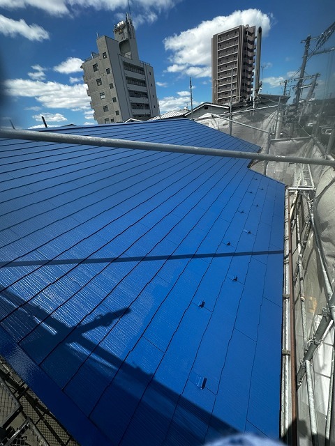 塗装が完了した青色のスレート屋根の全景