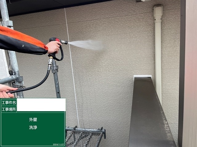 外壁を高圧洗浄して旧塗膜の粉化と汚れを洗い流す作業