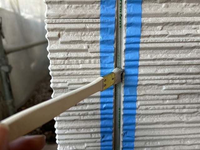 新しいシーリングのラインを出すためにマスキングテープを貼る作業
