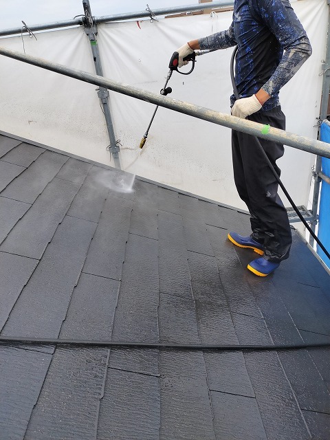 カラーベスト屋根を高圧洗浄している様子 黒い汚水が流れ落ちる