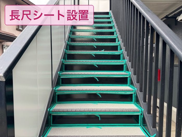 共用階段の踏み面に長尺シートを貼る作業