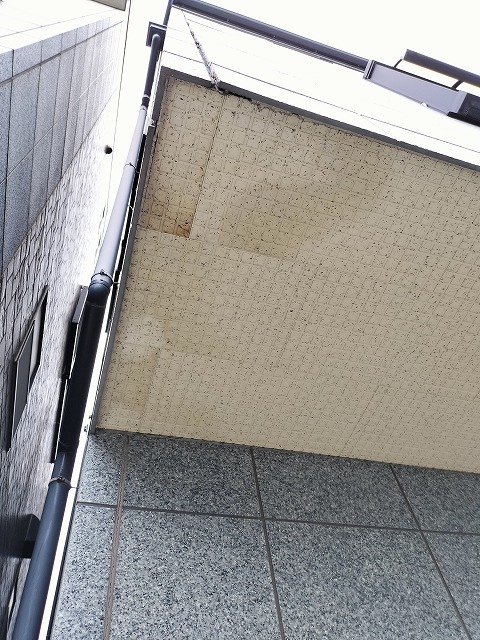 玄関上の軒天に雨染みが広がり継ぎ目が浮いた施工前の状態