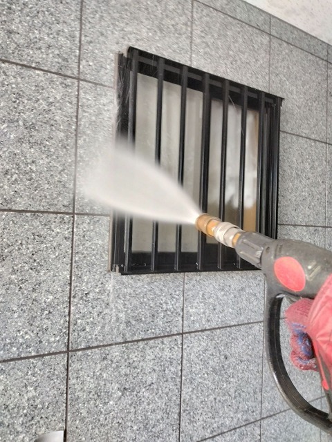 外壁の換気ガラリまわりを高圧洗浄機で洗っている様子