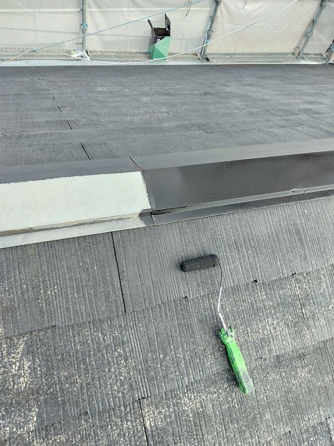 屋根の棟板金など鉄部にサビ止めを塗布している作業