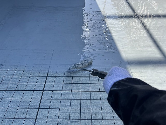 ウレタン防水材の1回目塗布。ローラーで均一に伸ばし、継ぎ目のない防水層をつくっていく ウレタン防水材の1回目塗布。ローラーで均一に伸ばし、継ぎ目のない防水層をつくっていく