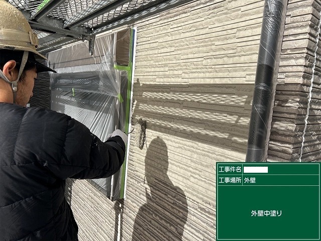 ローラーで外壁の中塗りを行う工程 ここで初めて色がのる