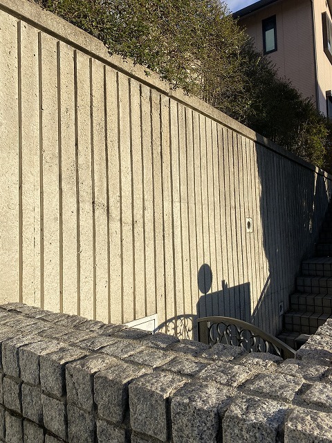 雨ざらしの擁壁。表面に黒い筋状の汚れが広がっている