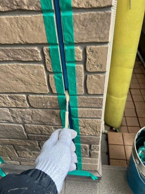刷毛で目地にシーリング専用プライマーを塗布しているところ