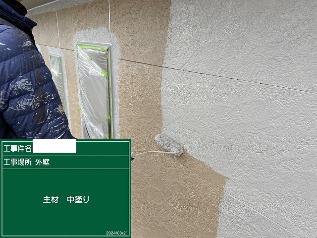 細かい凹凸のあるサイディング面に中塗りを塗っているところ