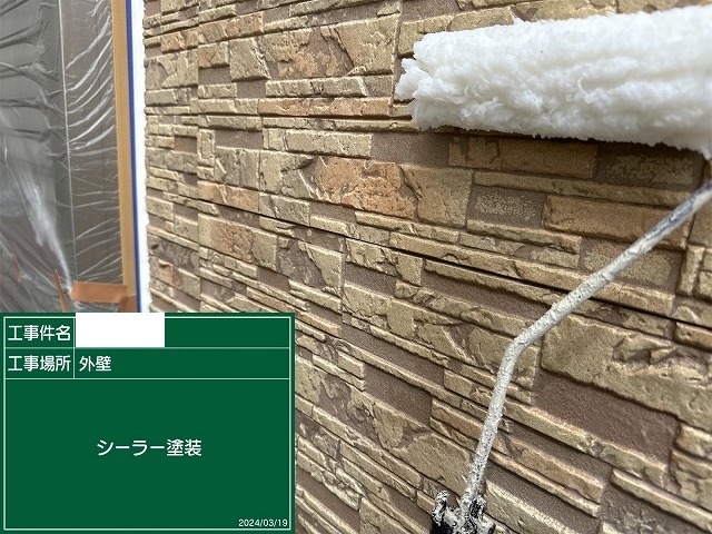 サイディング外壁に下塗りのシーラーをローラーで塗布しているところ