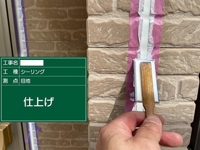 ヘラでシーリングを押さえて表面をならし仕上げている職人の手元