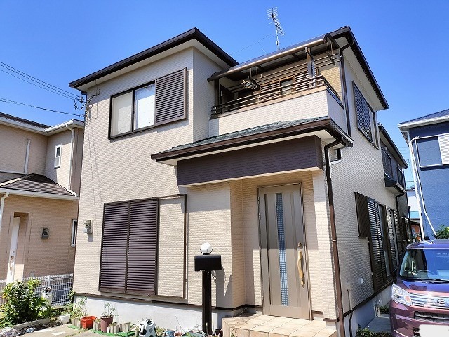 泉南市岡田 塗り替え後のサイディング外壁と屋根の全景 玄関上部だけ茶色の差し色