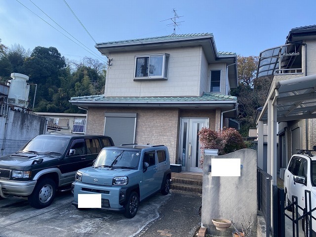 大阪市鶴見区 築24年の窯業系サイディング外壁 施工前の全景 緑の瓦屋根と色あせた外壁